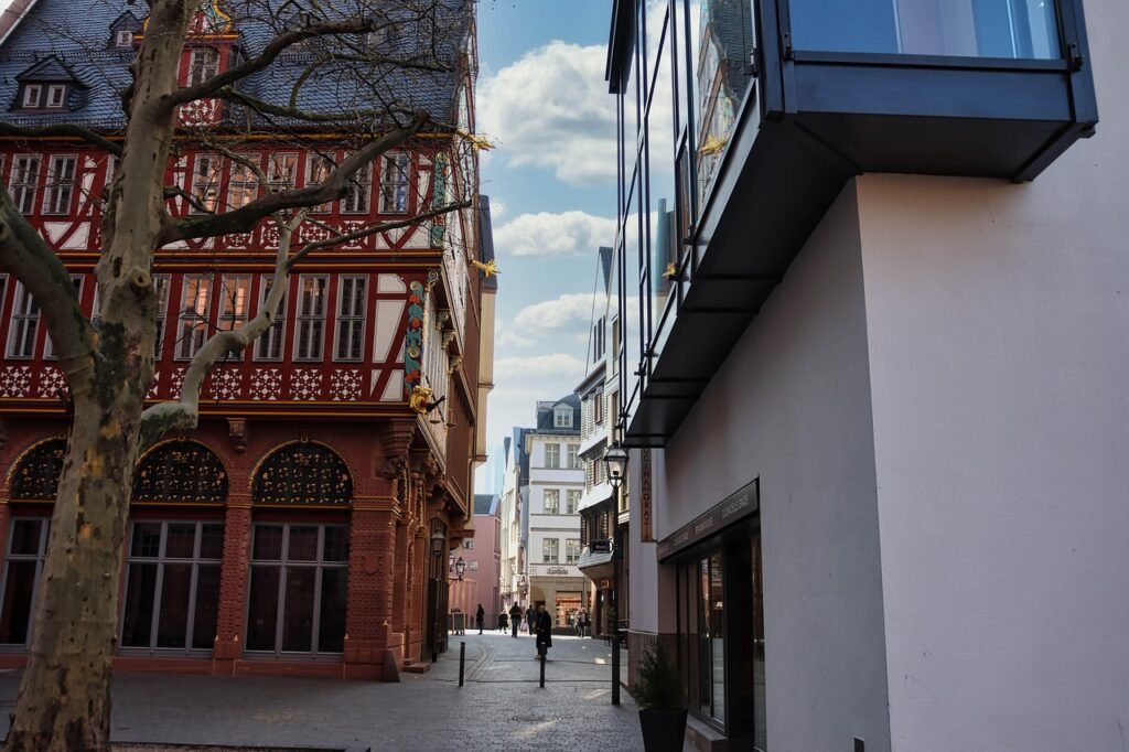 building, street, house, city, window, architecture, town, urban, road, sky, outdoors, sidewalk, alley, tower, home, downtown