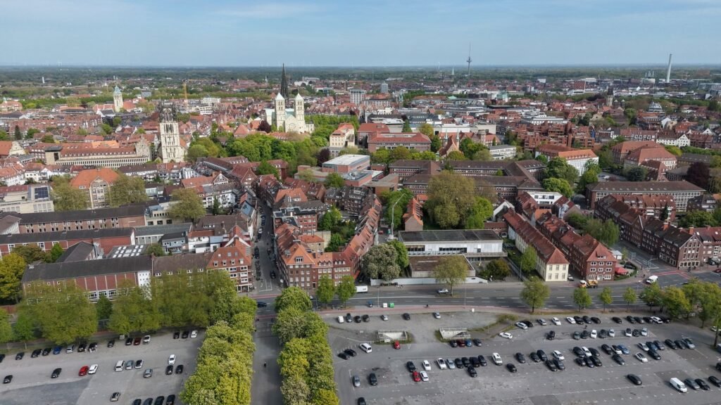 Luftaufnahme der historischen Architektur und des üppigen Grüns von Münster an einem sonnigen Tag.