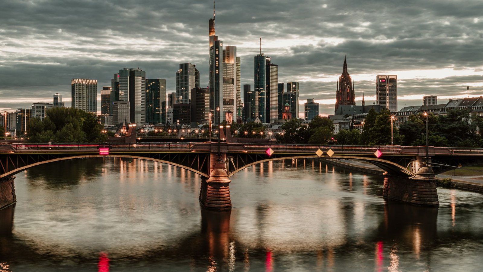Beeindruckende Aussicht auf die Skyline von Frankfurt am Main mit Spiegelungen im Fluss bei Dämmerung.