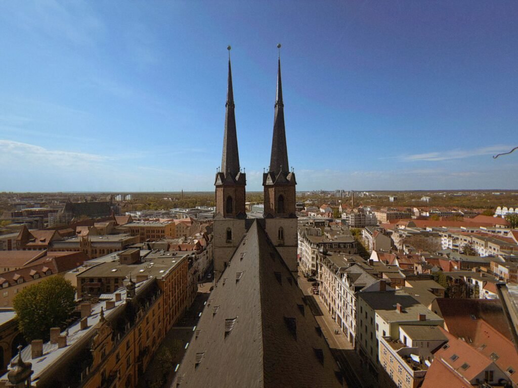 Aerial view of Halle (Saale), Germany showcasing the iconic Marktkirche and cityscape under a clear blue sky.