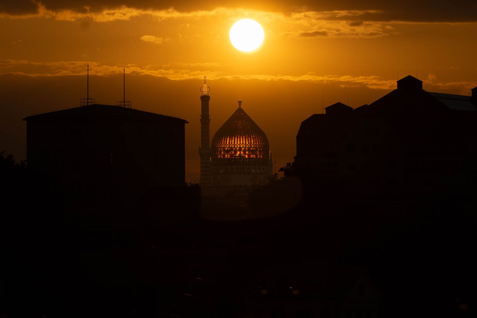Silhouette der Skyline von Dresden mit einem leuchtenden Sonnenuntergang im Hintergrund, der architektonische Merkmale hervor