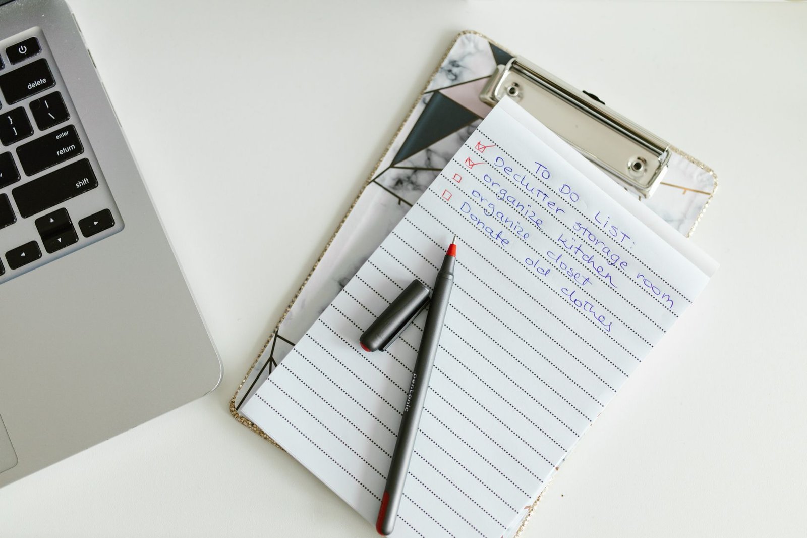 Notizbuch mit Checkliste und Laptop auf einem Tisch als Symbol für die Prüfung von Escort-Profilen
